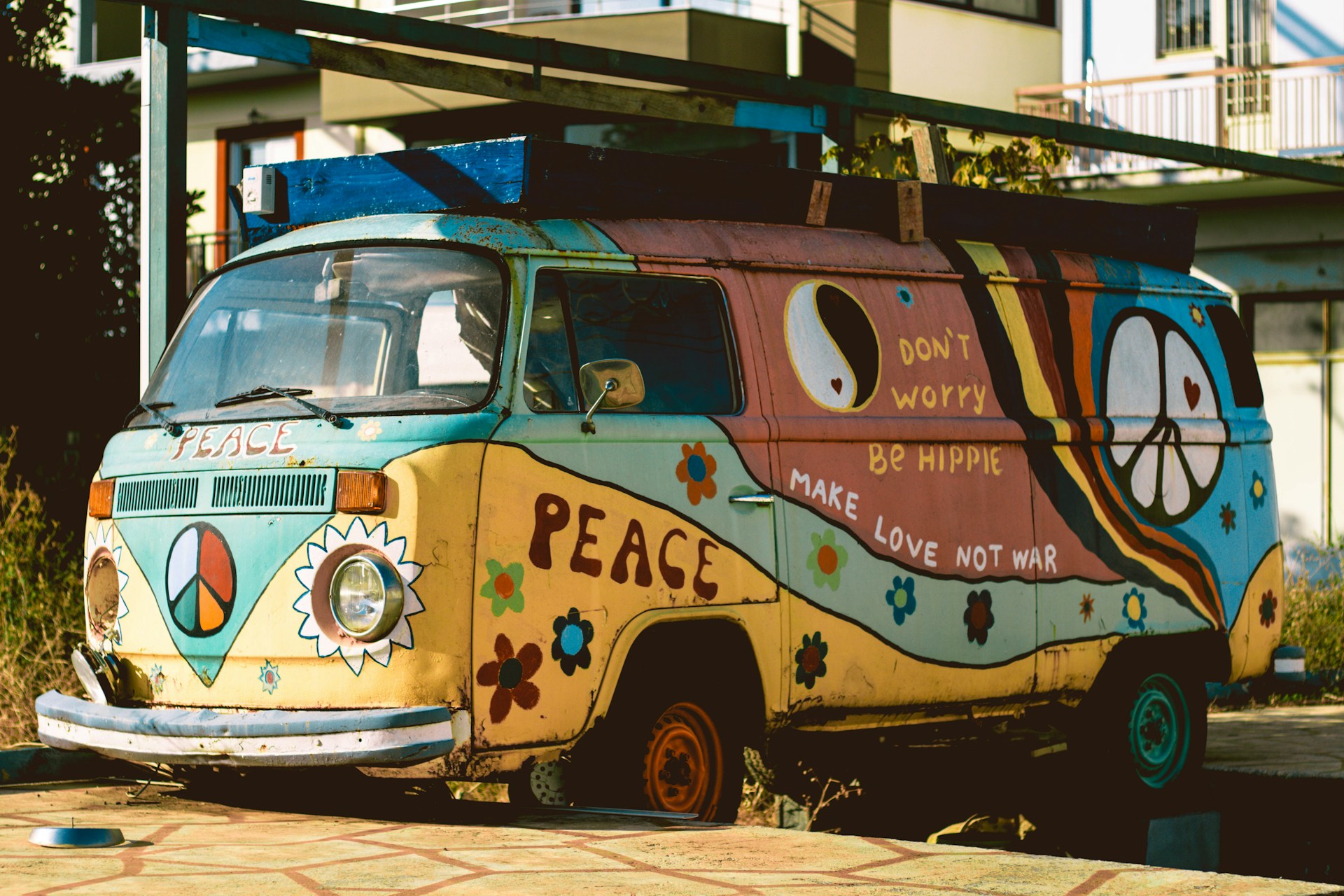 A hippie camper with "don't worry, be hippie", "make love not war", and "peace" written on it.